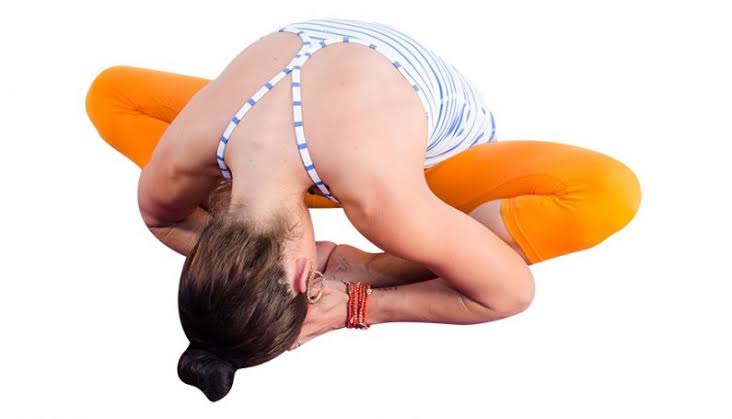 Yoga student in Cobbler's Pose stretching hips and groin.