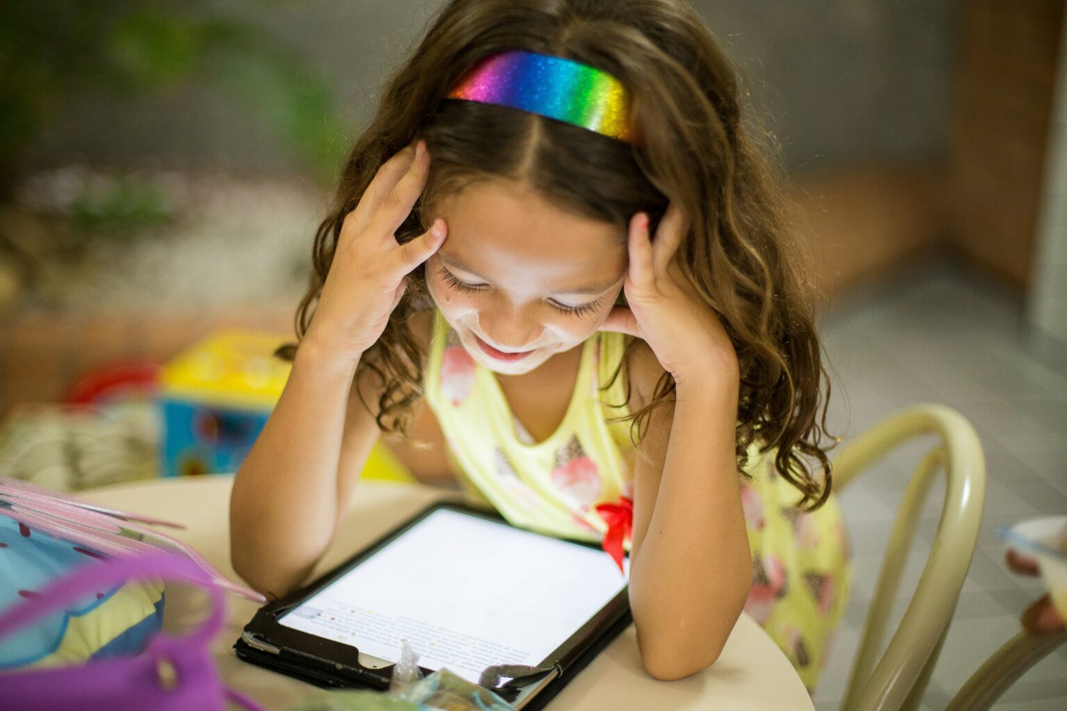 Children’s Privacy Online Young child playing a game on a tablet while data icons float in the background representing data collection."